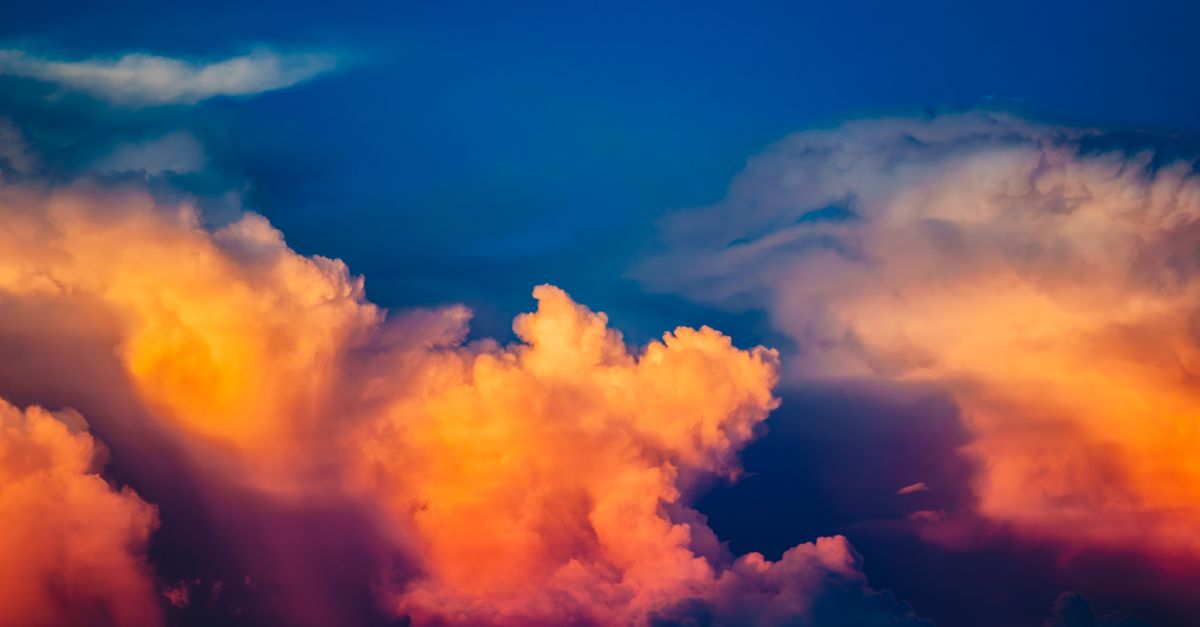 Vibrant clouds illuminated by a stunning sunset, showcasing vivid hues in a calm sky.